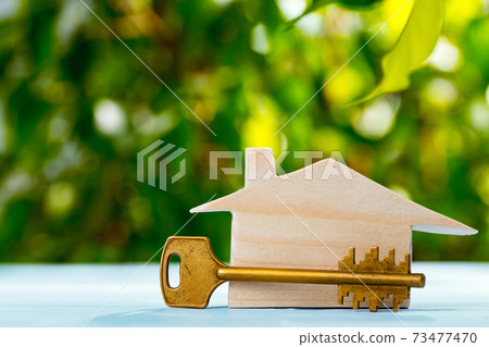 Wooden toy house and house keys close up 73477470