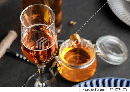 Glass of wine and corkscrew on black table Glass of wine and corkscrew on black table 73477473