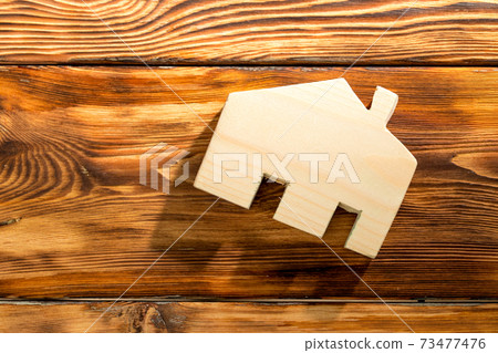Wooden house miniature on wooden surface close up Wooden house miniature on wooden surface close up 73477476