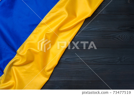 National flag of Ukraine on dark wooden background National flag of Ukraine on dark wooden background 73477519