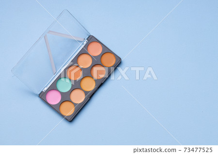 Set of eyeshadows on blue background close up Set of eyeshadows on blue background close up 73477525