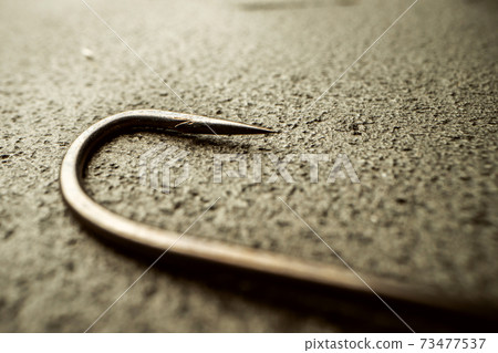 Fishing hooks on concrete textured background macro Fishing hooks on concrete textured background macro 73477537