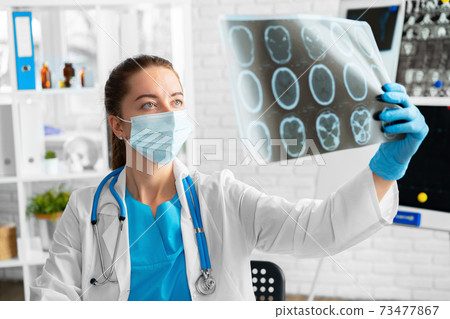 Woman doctor examines head mri scan in hospital 73477867