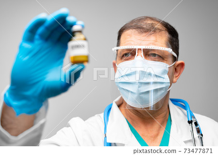 Senior man doctor or scientist holding vaccine vial Senior man doctor or scientist holding vaccine vial 73477871