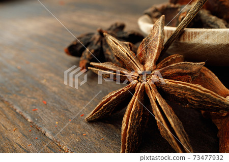 Macro photo of anise stars on wooden background 73477932
