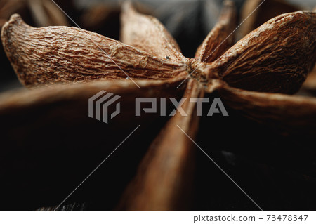 Macro photo of anise stars on wooden background Macro photo of anise stars on wooden background 73478347