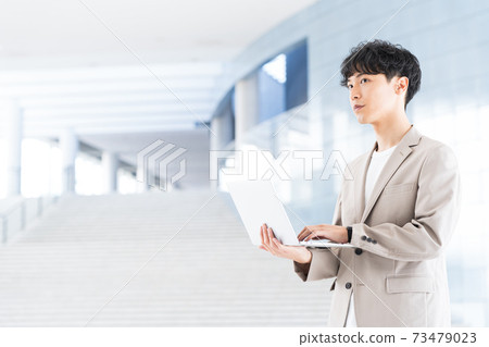 Young businessman with a laptop in the office Young businessman with a laptop in the office 73479023