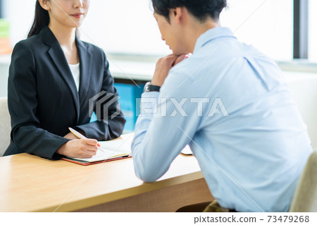 Business woman listening to the worries of young men 73479268
