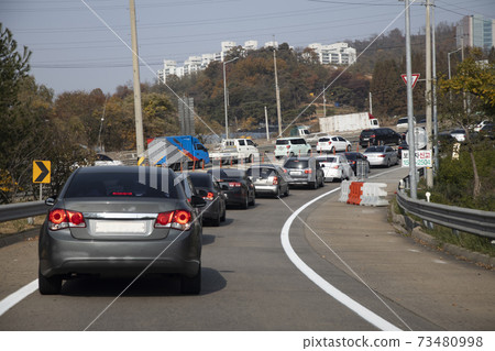 Vehicles moving slowly in traffic jam 73480998