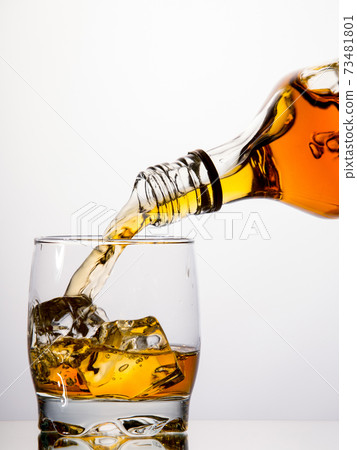 Pouring whisky from a bottle Pouring whisky from a bottle 73481801