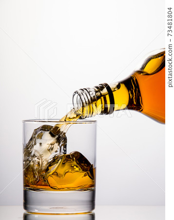 Pouring whisky from a bottle Pouring whisky from a bottle 73481804