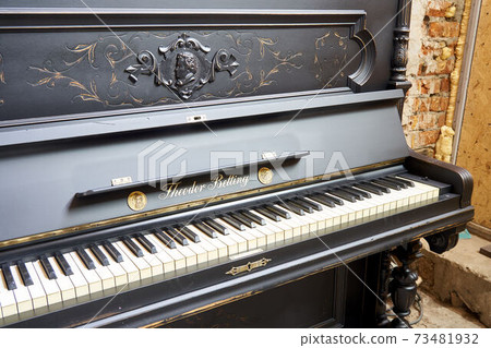Old-fashioned antique ornamental piano with carved pillars. After restoration 73481932