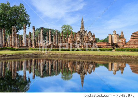 Pagoda and ruined monastery complex at Wat Mahathat temple with reflection, Sukhothai Historical Park, Thailand 73483973