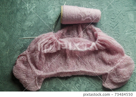 Knitting background flatlay.Kknitted pullover on a concrete background. Knitting background flatlay.Kknitted pullover on a concrete background. 73484550