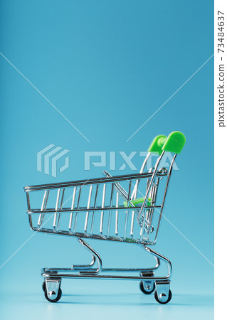 An empty supermarket cart on a blue background. An empty supermarket cart on a blue background. 73484637