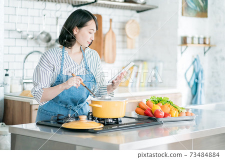 A housewife using a tablet in the kitchen 73484884