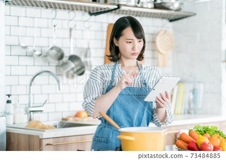 A housewife using a tablet in the kitchen 73484885