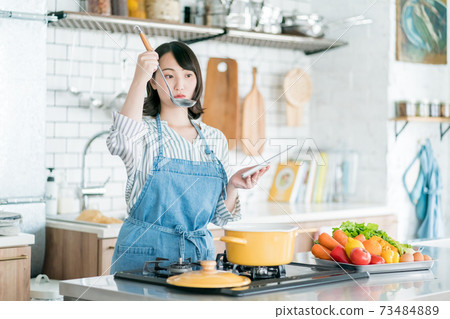 使用片劑的一位主婦在廚房裡 73484889