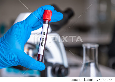 Researcher or medical technician doctor holding test tube contain blood sample with COVID-19 infection in laboratory for research to discover vaccine.. 73484972