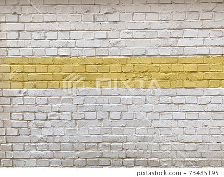 建築物的外牆，在舊磚牆上塗上新的白色和黃色油漆 73485195