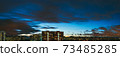 Night long panorama of the roofs of the buildings and lit windows 73485285