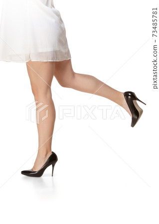 Attractive female legs in romantic white attire and black stylish shoes. Attractive female legs in romantic white attire and black stylish shoes. 73485781