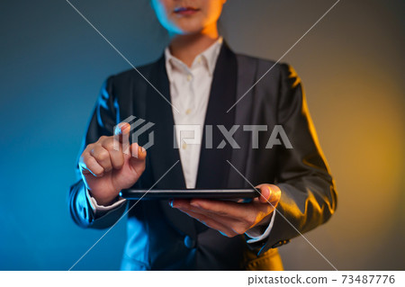 Business woman holding smart phone in black suit. Business woman holding smart phone in black suit. 73487776