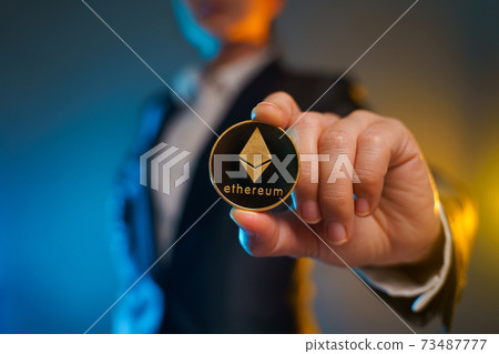 Close up shot of Business woman holding golden coin. Close up shot of Business woman holding golden coin. 73487777