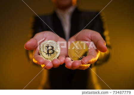 Close up shot of Business woman holding golden coin. Close up shot of Business woman holding golden coin. 73487779