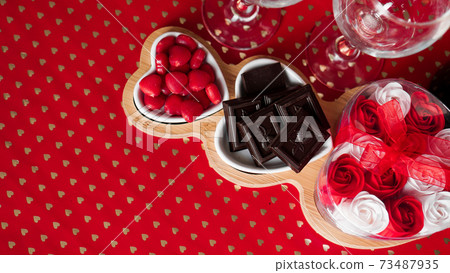 Chocolates and sweets on heart-shaped plates. Festive table setting for date Chocolates and sweets on heart-shaped plates. Festive table setting for date 73487935
