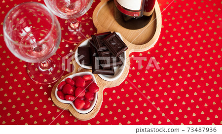Chocolates and sweets on heart-shaped plates. Festive table setting for date Chocolates and sweets on heart-shaped plates. Festive table setting for date 73487936