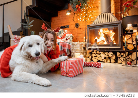 Woman with dog during New Year holidays at home Woman with dog during New Year holidays at home 73489238