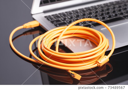 laptop with orange rolled cable laptop with orange rolled cable 73489567