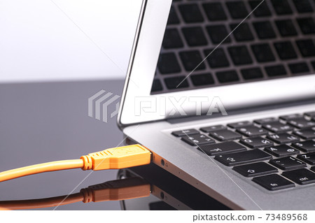 laptop with orange rolled cable laptop with orange rolled cable 73489568