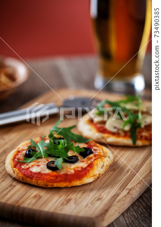 Mini Pizzas served on Wooden Board. High quality photo. 73490385