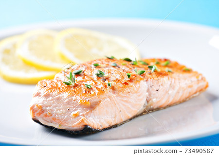 Fillet of salmon with asparagus on a plate. Fillet of salmon with asparagus on a plate. 73490587