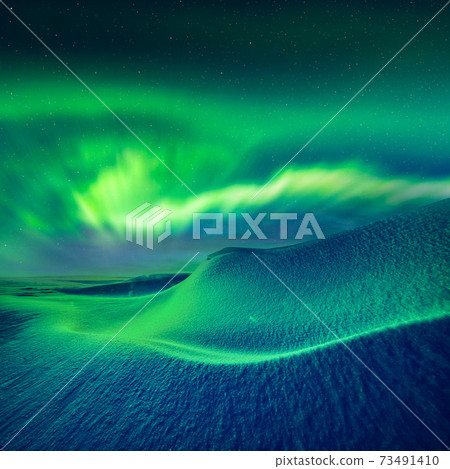Aurora borealis over fantastic winter landscape in snowy mountains Aurora borealis over fantastic winter landscape in snowy mountains 73491410
