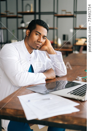 Stressed African American black man doctor looking at laptop reading bad news online 73491754
