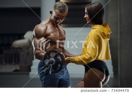 Sporty fitness couple working out in gym Sporty fitness couple working out in gym 73494479
