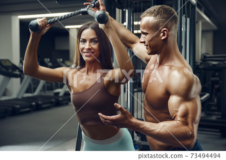 Sporty fitness couple working out in gym Sporty fitness couple working out in gym 73494494