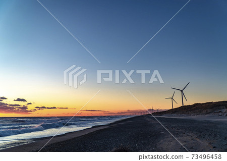 A group of wind power generators at sunset on the Hamaoka sand dunes and beaches along the sea in Omaezaki City, Shizuoka Prefecture 73496458