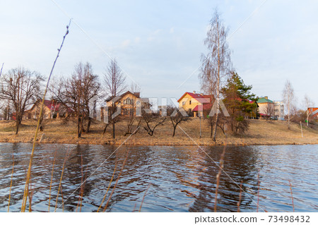 Houses of the Belarusian village on the river bank Houses of the Belarusian village on the river bank 73498432