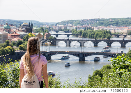 Person in front of Prague panorama charles bridge river from mountain skyview Person in front of Prague panorama charles bridge river from mountain skyview 73500553