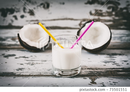 Coconut milk in a glass with two straws 73501551