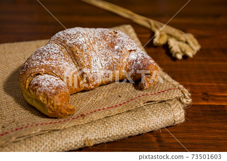 Croissant on a burlap and ears of wheat Croissant on a burlap and ears of wheat 73501603