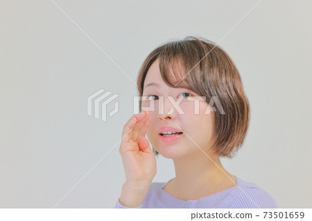 A woman whispering in a whisper A woman whispering in a whisper 73501659