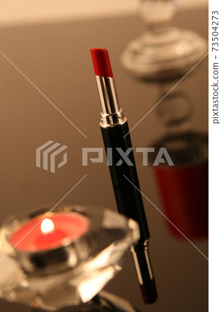 Red lipstick and candle 73504273