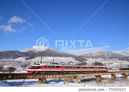 Nagano Electric Railway Limited Express Yukemuri crossing Yomasebashi with the snowy mountains of Kita-Shiga in the background 73505025