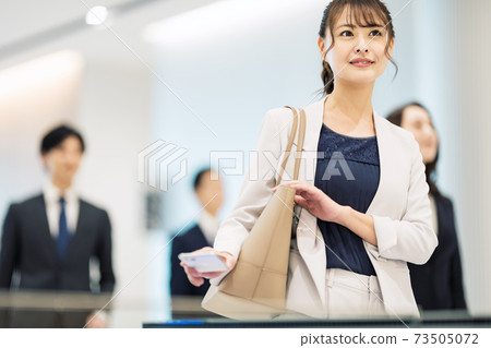 A woman passing through a security gate on her smartphone "LINK FOREST" A woman passing through a security gate on her smartphone "LINK FOREST" 73505072