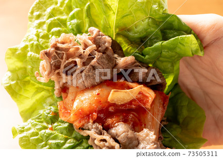 Wrap yakiniku and Chinese cabbage kimchi in lettuce and eat. 73505311